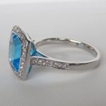 side view of blue topaz diamond halo ring