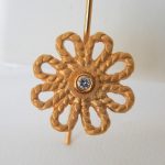 close up view of yellow gold diamond flower earring
