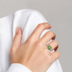 white gold peridot and diamond ring on finger