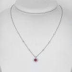 ruby and diamond halo necklace in white gold