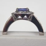 side view of white gold tanzanite and diamond halo ring