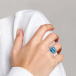 white gold blue topaz and diamond ring on finger