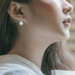 white gold blue topaz dangle earrings on model