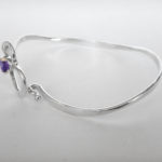 side view of sterling silver heart bangle with round amethyst in the center