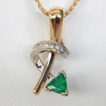 contemporary emerald and diamond pendant in yellow gold setting