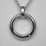 close up view of sterling silver single diamond circle pendant