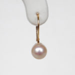 close up view of yellow gold pearl earrings