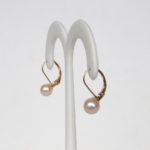 side view of yellow gold pearl dangle earrings