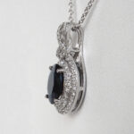 side view of white gold oval sapphire and diamond pendant