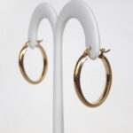 side view of oval yellow gold hoops