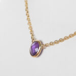 side view of yellow gold amethyst solitaire necklace