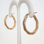 side view of yellow gold twisted oval hoop earrings
