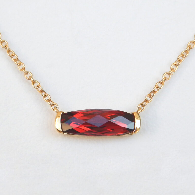 close up view of yellow gold garnet necklace