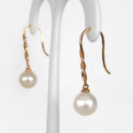 side view of yellow gold pearl drop earrings
