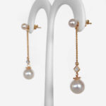 side view of yellow gold pearl and diamond dangle earrings