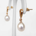 side view of yellow gold pearl and diamond dangle earrings