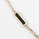 close up view of yellow gold black onyx station necklace