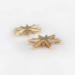 side view of two tone gold starburst stud earrings