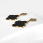 side view of yellow gold black onyx clover earrings