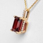 side view of yellow gold garnet and diamond pendant