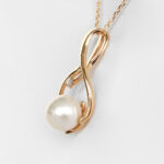 side view of yellow gold pearl and diamond pendant