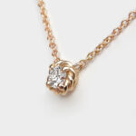side view of yellow gold diamond solitaire necklace