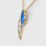 side view of yellow gold blue and white enamel diamond pendant