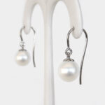 side view of white gold freshwater pearl dangle earrings