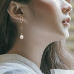 yellow gold paperclip dangle earrings on model