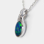 side view of white gold opal and diamond pendant