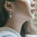 sterling silver onyx and mother of pearl dangle earring on ear