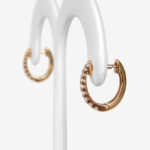 side view of yellow gold huggie hoop earrings